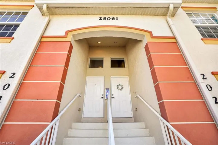 Doorway to property featuring stucco siding