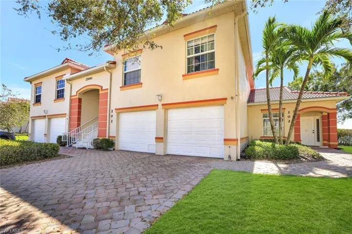 View of front of home with a garage, a tile roof, decorative driveway, and stucco siding