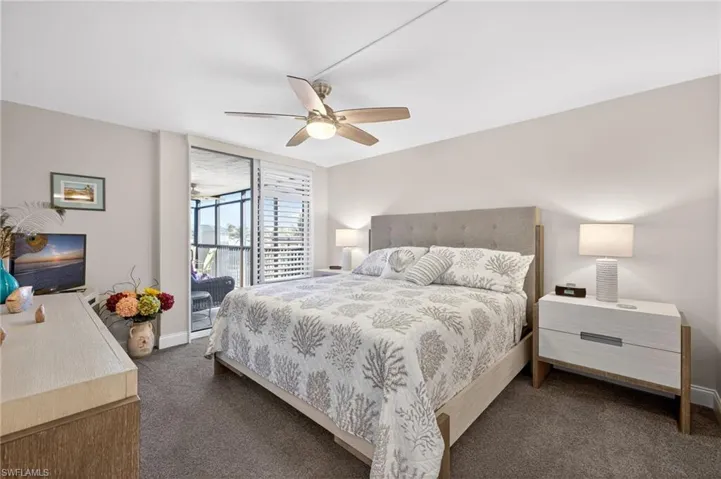 Bedroom with a ceiling fan and dark colored carpet