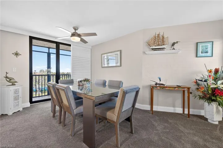 Dining space featuring carpet floors, a ceiling fan, and floor to ceiling windows