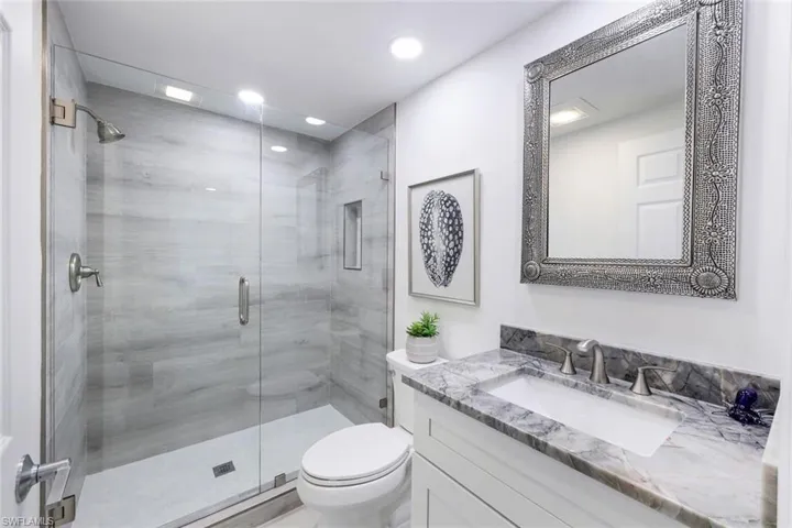Bathroom with vanity, toilet, a shower stall, and recessed lighting