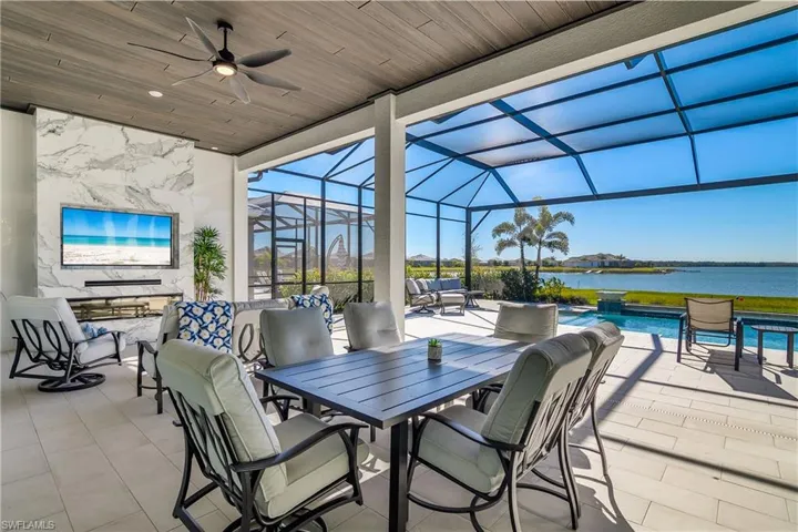 Sprawling outdoor living space with custom details including tile pavers, tongue and groove ceiling, and custom tiled feature wall with built-in TV and fireplace.