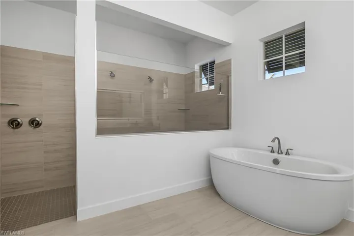 Spa-like primary bath with oversized walk-in shower and soaking tub.