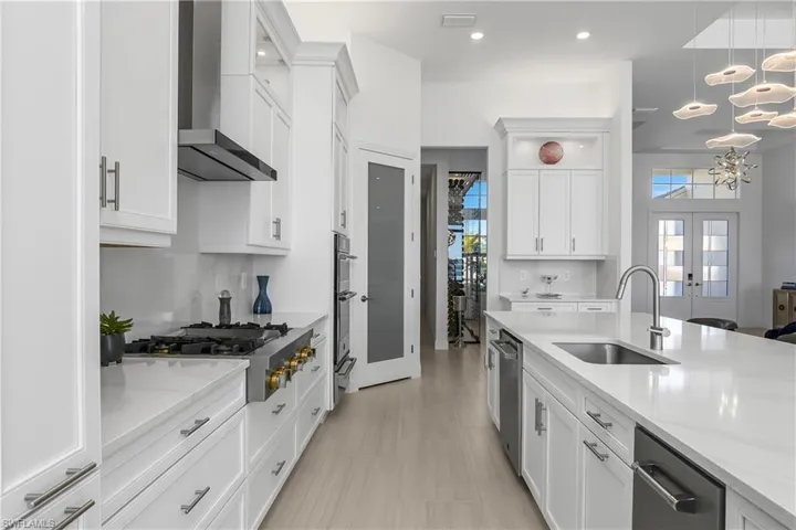 Oversized island includes under counter XO brand icemaker with drain and Jennair RISE built-in dishwasher.
