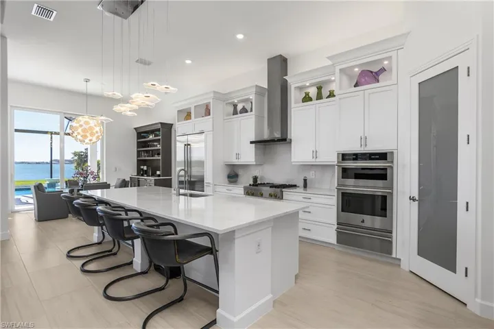 The kitchen of this home is custom built by Cornerstone, with solid wood cabinets with lighted double glass uppers, new solid glass pantry door, and new Jennair RISE professional appliances.