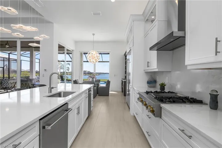 Kitchen is accented by one-of-a-kind designer lighting from Lighting and Design Studio of Naples.