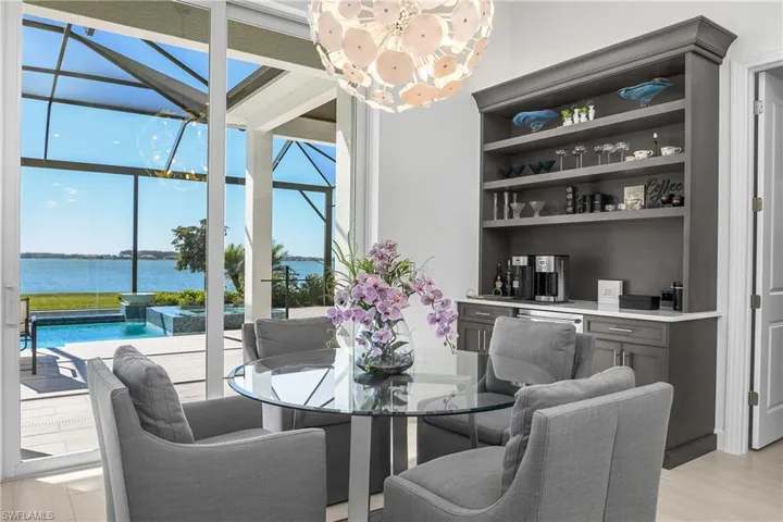 The kitchen cafe area is the perfect spot to enjoy your morning coffee and features additional high-end interiors: Designer Chandelier, Custom-Built by Cornerstone Beverage service area with hand-made custom cabinetry, quartz countertop and XO brand double refrigerated drawers.