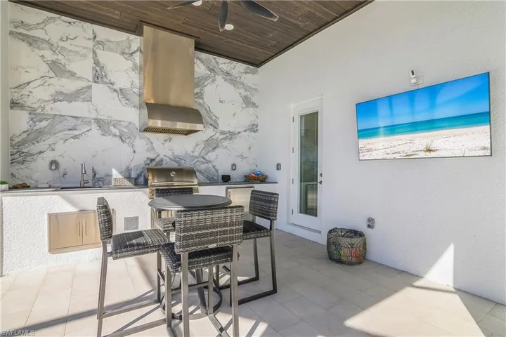 Enjoy entertaining and cooking on your lanai which includes an outdoor kitchen has been completely redone with  newly installed tile backsplash, natural gas grill, beverage cooler and sink. Door leads to POOL BATH.