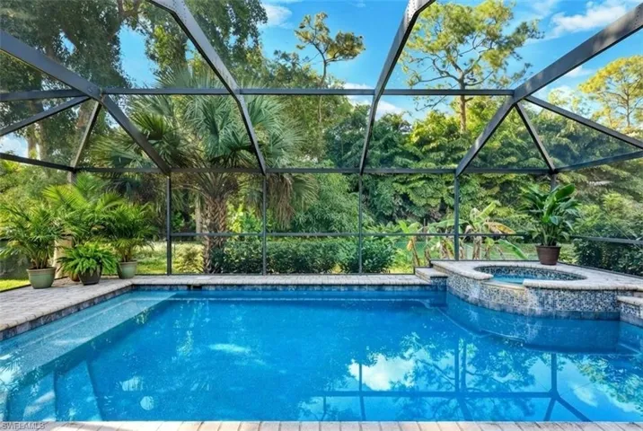 View of pool with connected hot tub, and a lanai