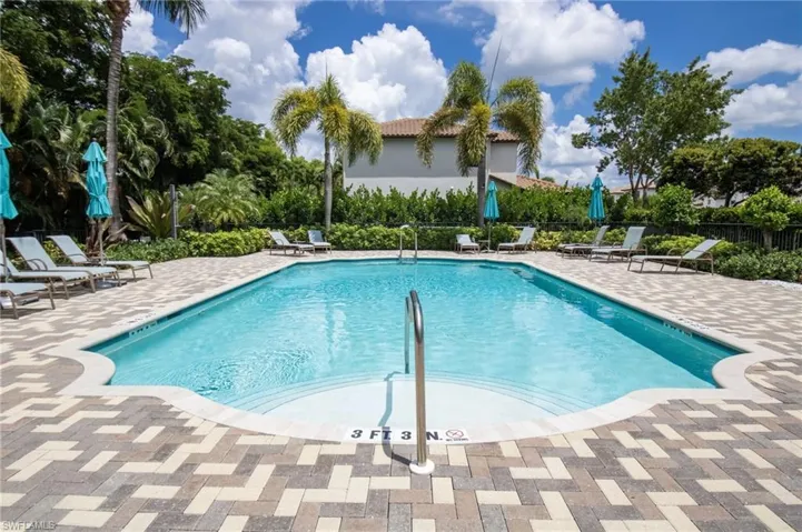 Rectangular swimming pool with curved entry steps, surrounded by a paver deck
