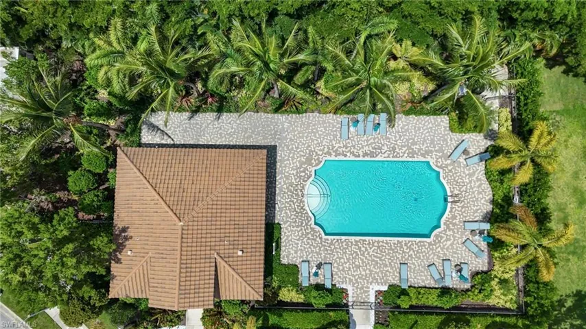 Tile roof with multiple gables, surrounded by lush green landscaping