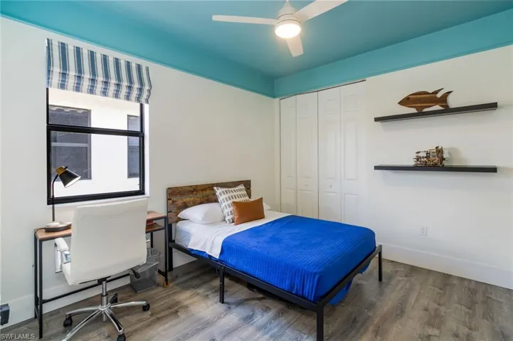 Wood-finish flooring with white walls and a blue ceiling