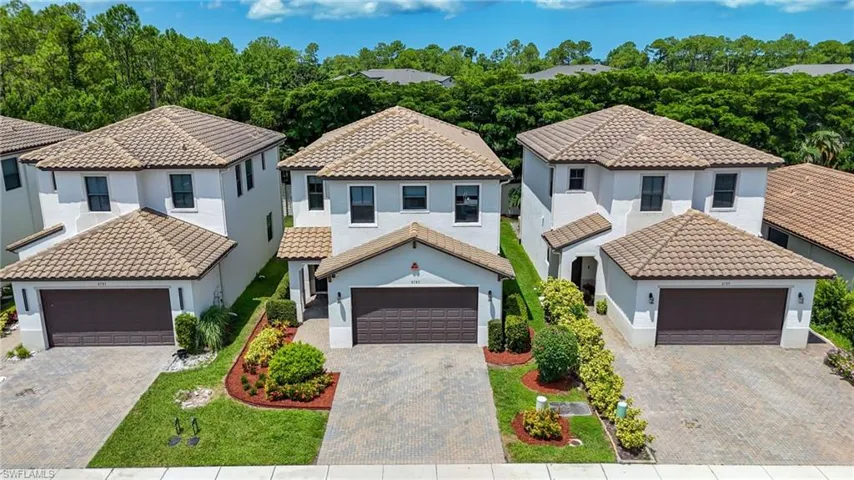 Mediterranean-style residence featuring a tile roof, stucco exterior, and attached garage