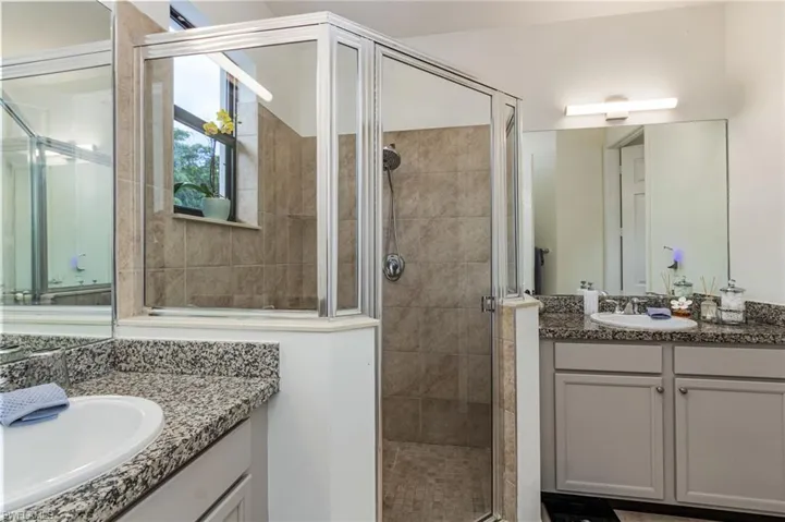 Glass-enclosed shower with tiled walls and a window