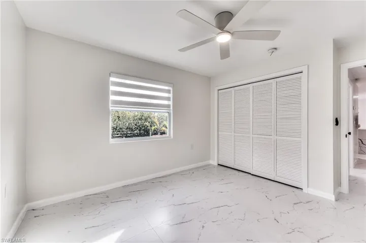 Unfurnished bedroom with ceiling fan and a closet