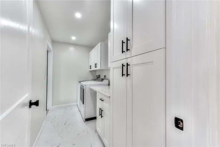 Laundry area with independent washer and dryer and cabinets