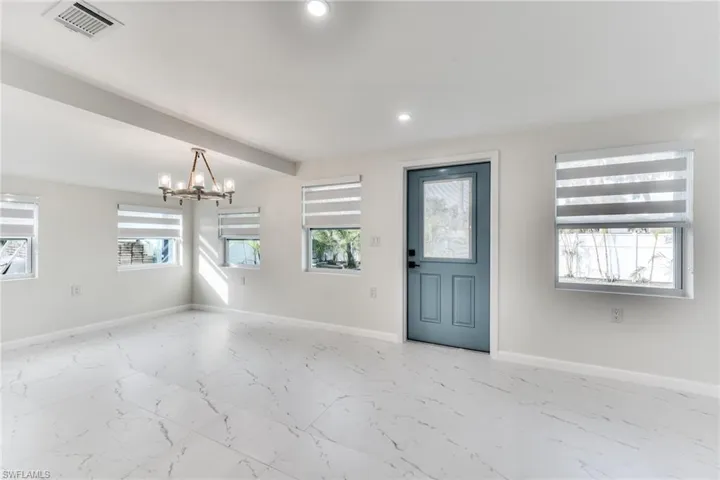 Entryway featuring an inviting chandelier and beam ceiling