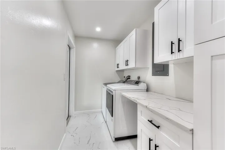 Laundry area featuring cabinets and washer and clothes dryer