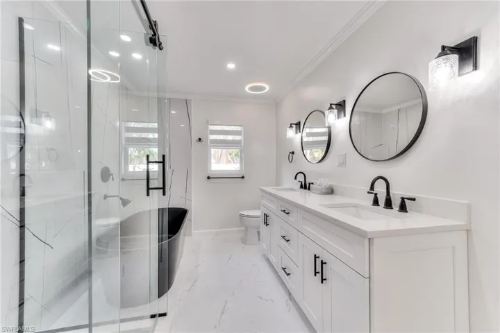 Bathroom with toilet, vanity, walk in shower, and ornamental molding
