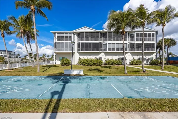 View of community with shuffleboard and a lawn