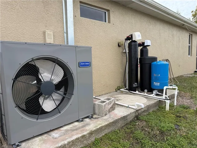 Exterior view of stucco siding and a water softener