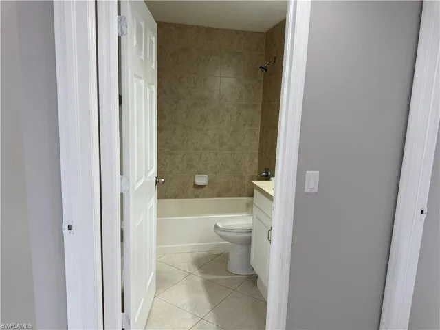 Bathroom with vanity, light tile patterned flooring, and bathing tub / shower combination