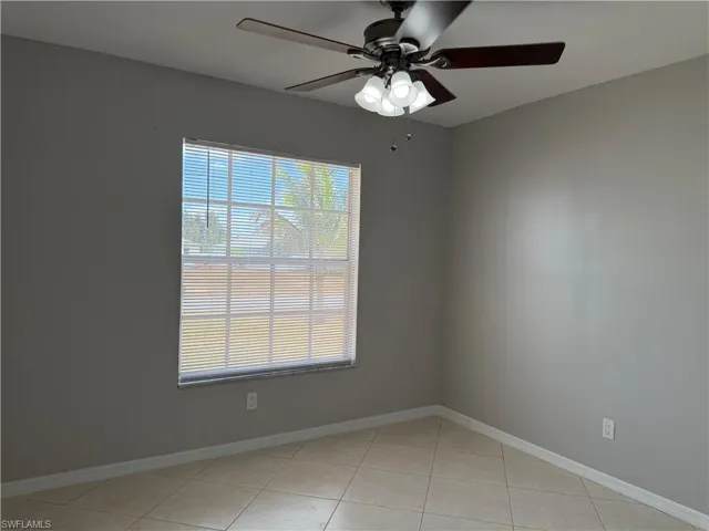 Unfurnished room featuring a ceiling fan and light tile patterned floors