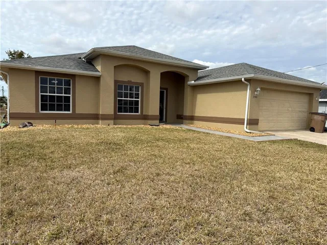 View of front of house featuring stucco siding, a front yard, an attached garage, and concrete driveway