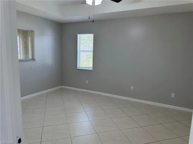 Spare room with a ceiling fan and light tile patterned floors