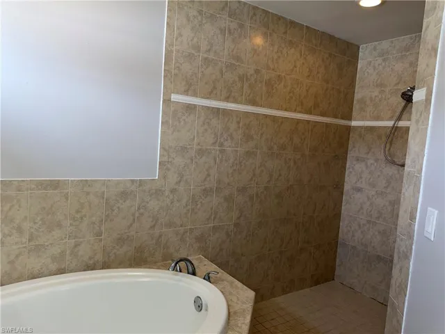 Full bathroom featuring a bath, a tile shower, and recessed lighting