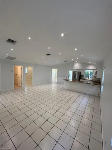 Unfurnished living room with recessed lighting and light tile patterned floors