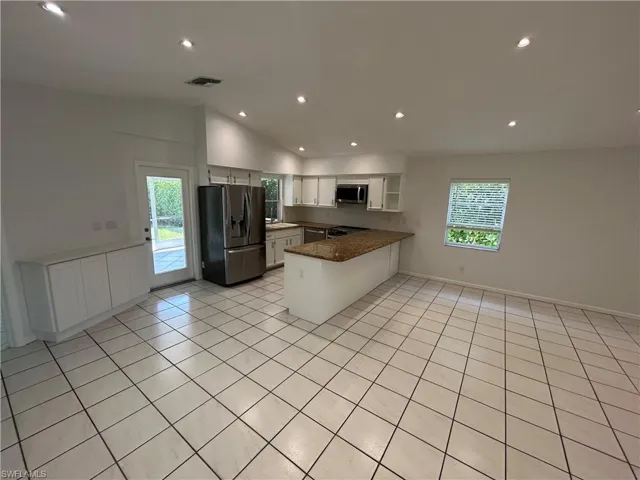 Kitchen featuring stainless steel appliances, a peninsula, white cabinetry, recessed lighting, and plenty of natural light