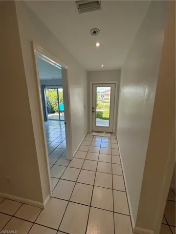 Doorway to outside with tile patterned floors and recessed lighting