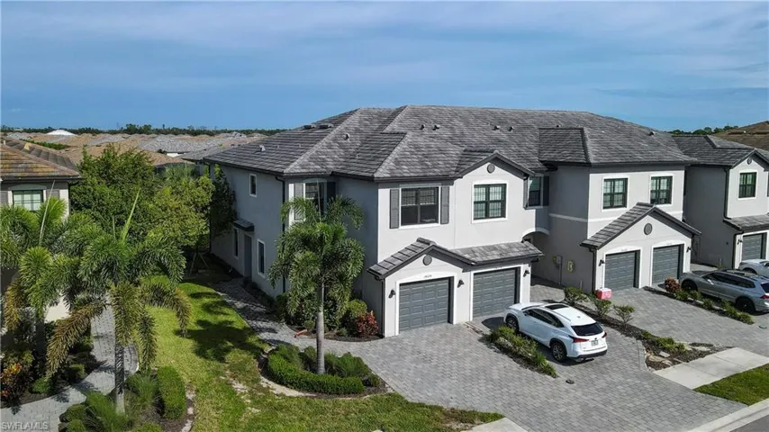 View of front facade with stucco siding, a garage, decorative driveway, and a high end roof