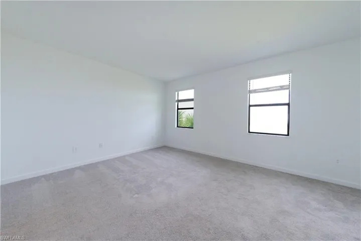 Unfurnished room with light carpet and baseboards