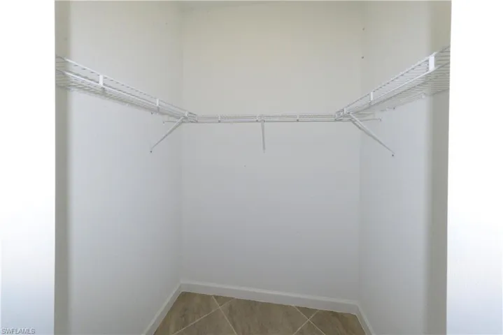 Walk in closet with light tile patterned floors