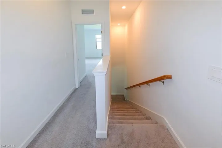 Staircase with carpet flooring and recessed lighting