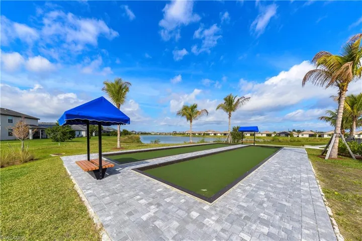 View of home's community featuring a bocce ball area, a yard, a water view, and a residential view