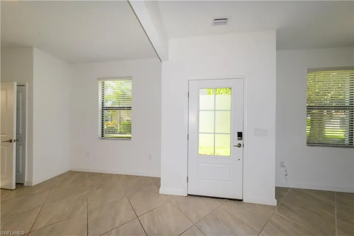 Entryway featuring baseboards and light tile patterned floors