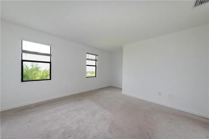 Empty room with light carpet and baseboards
