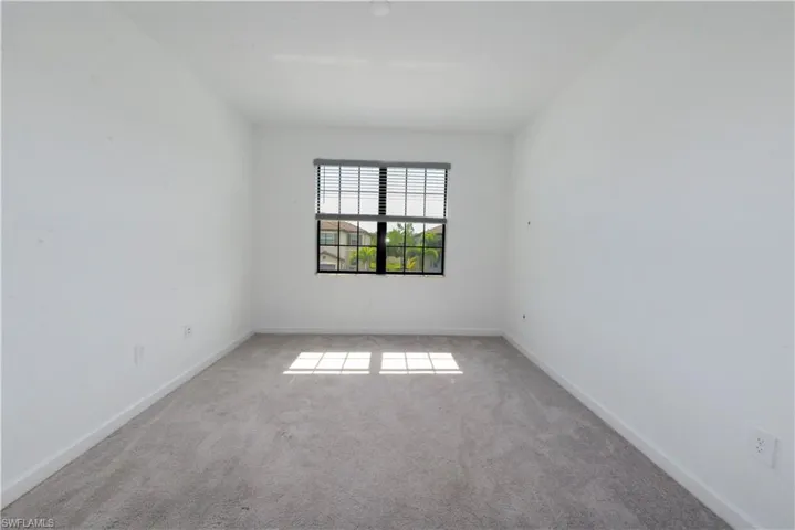 Carpeted empty room with baseboards