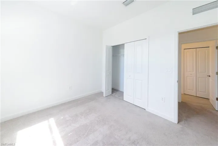 Unfurnished bedroom featuring light colored carpet and a closet