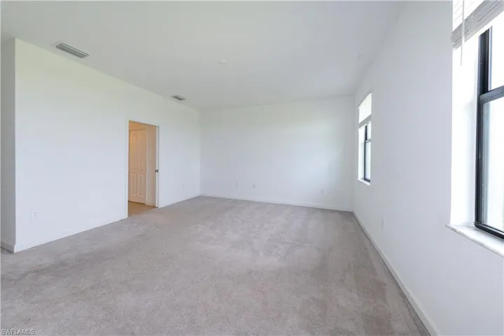 Unfurnished room with light carpet and baseboards