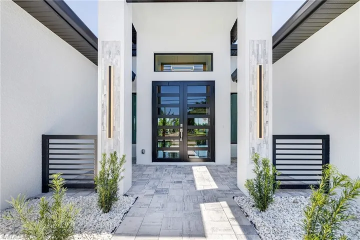Property entrance with stucco siding and french doors