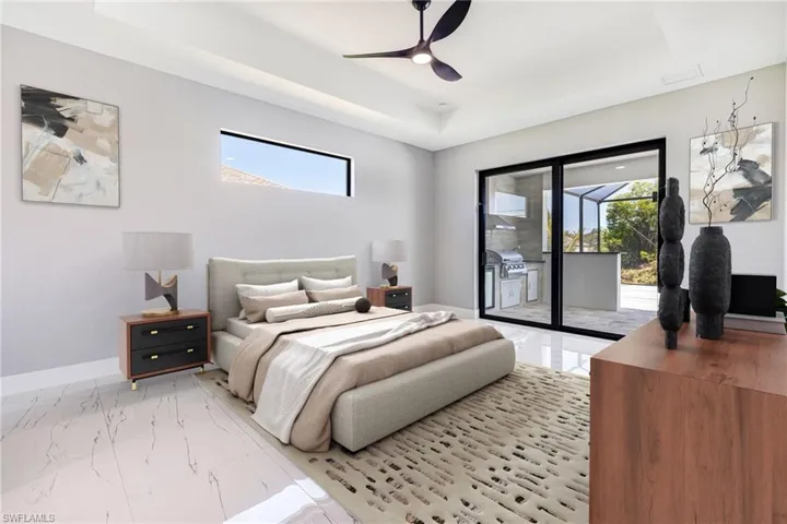 Bedroom with access to exterior, a raised ceiling, multiple windows, and light marble finish floors