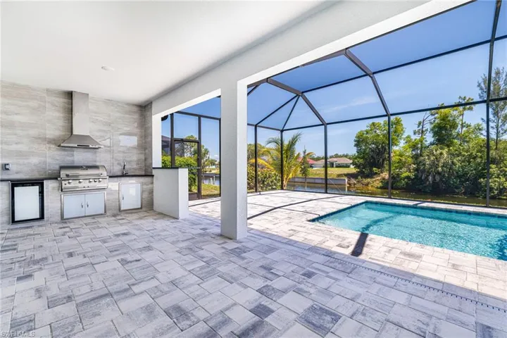 Swimming pool with a patio area and glass enclosure