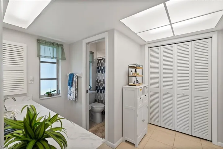 Tiled bedroom with ensuite bath and a closet