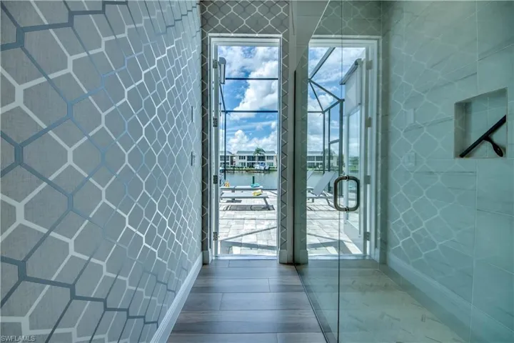 Bedroom featuring wood tiled floors, a closet, and wallpapered walls