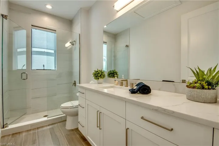 Full bathroom featuring vanity, a shower stall, and wood tiled floors
