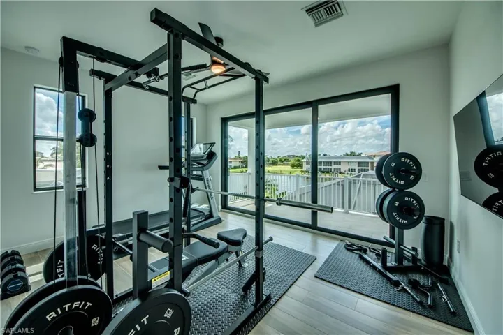 Workout area featuring healthy amount of natural light and light wood finished floors